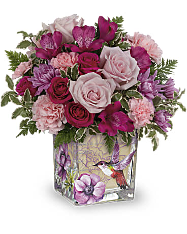 Pink and magenta bouquet in a square glass vase with a hummingbird design