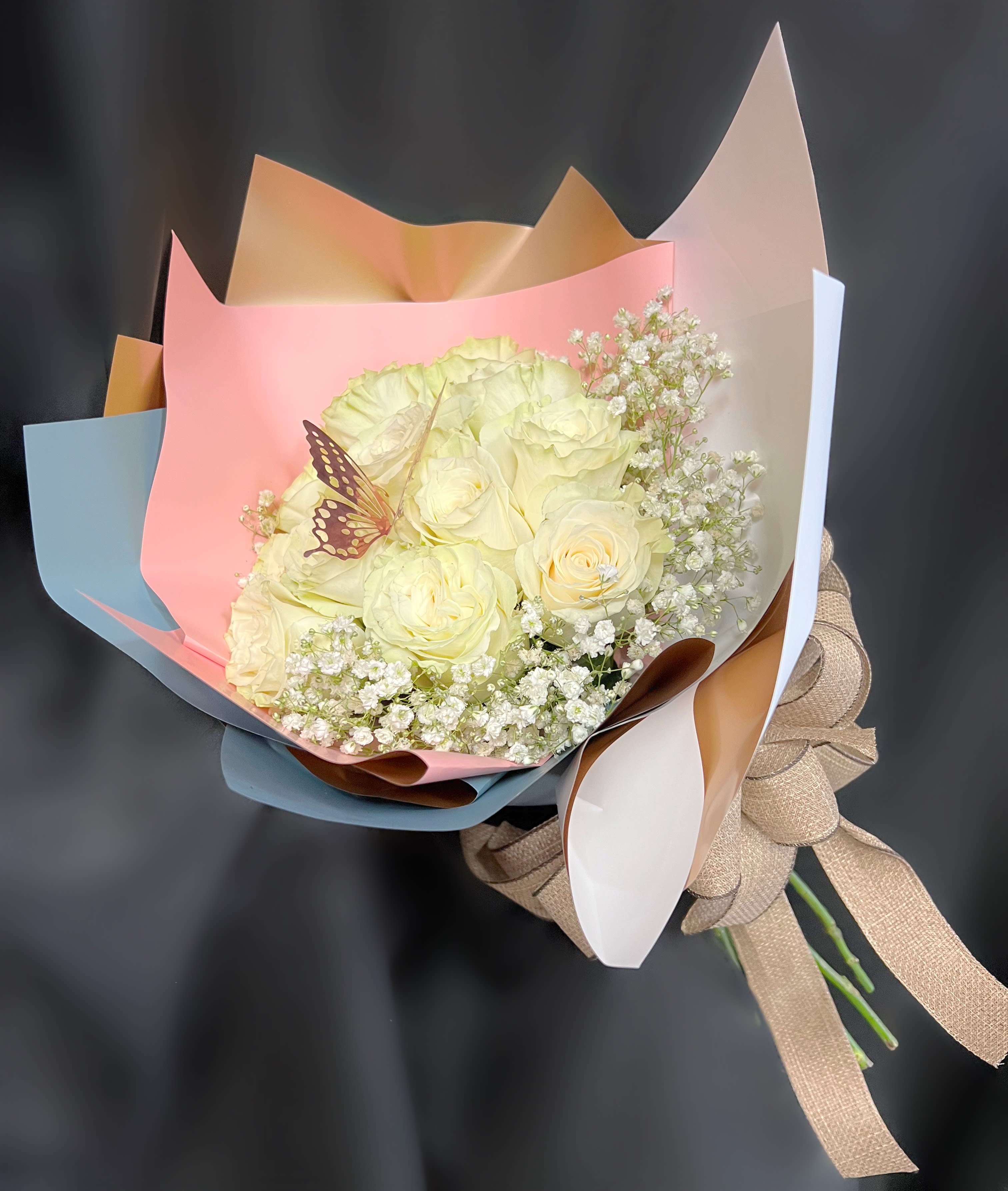 Bouquet of pale yellow roses with baby's breath in pastel wrapping