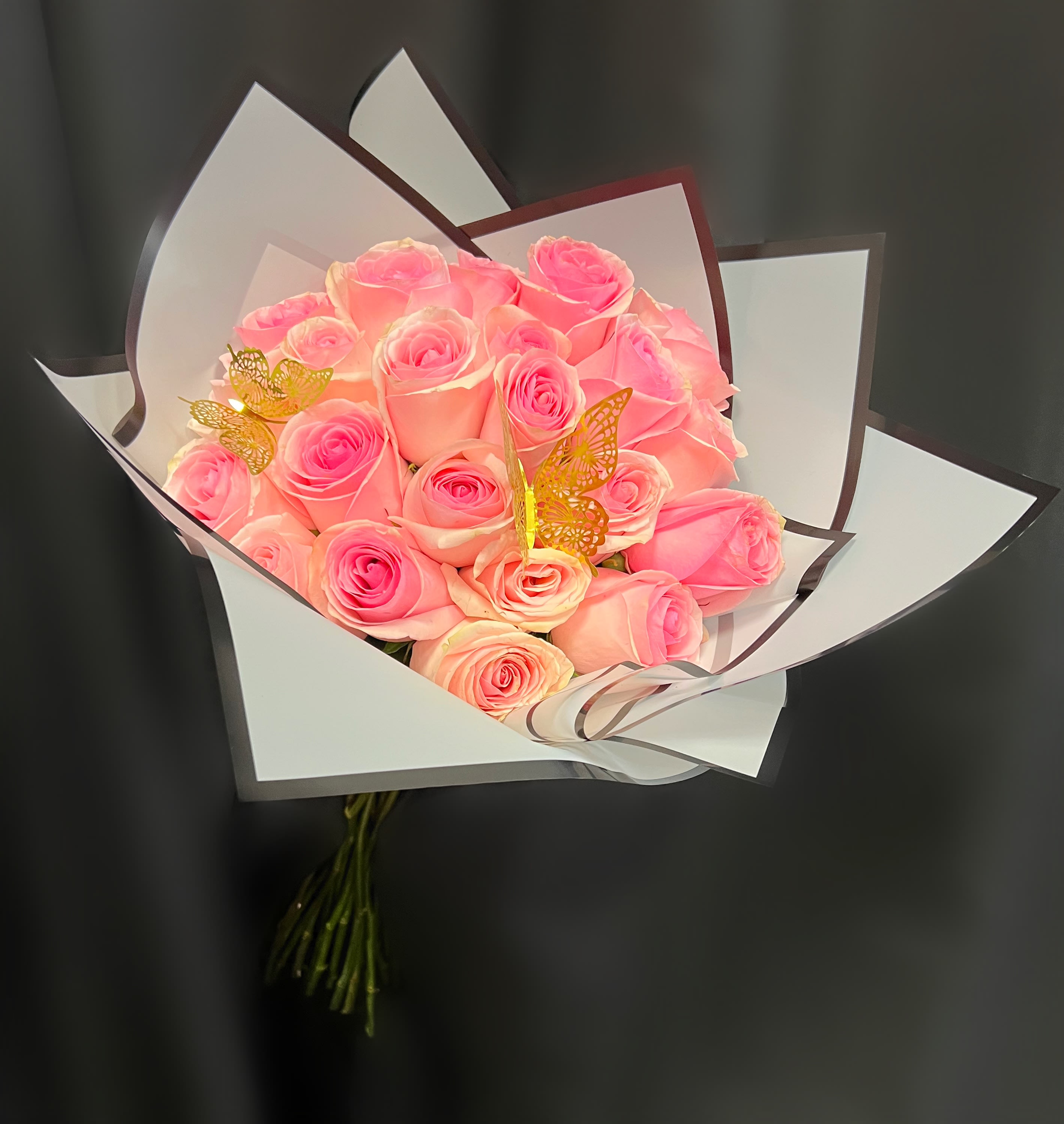 Bouquet of pink roses wrapped in white paper