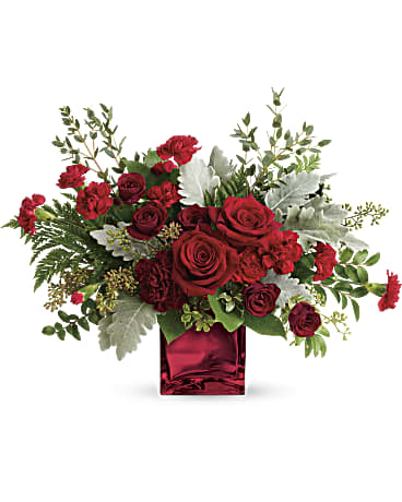 Red roses arranged in a square red vase with silver foliage