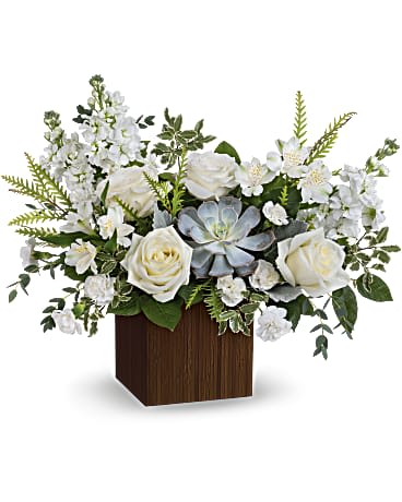 White roses and mixed white flowers in a wooden cube vase