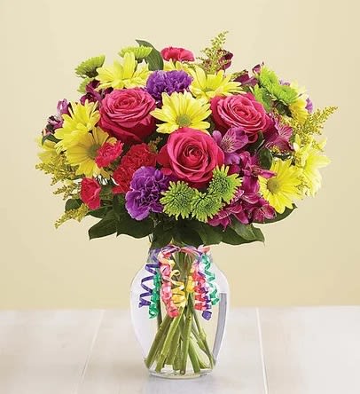 Bouquet of pink roses and yellow daisies in a glass vase