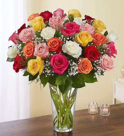 Mixed bouquet of multicolored roses in a clear glass vase