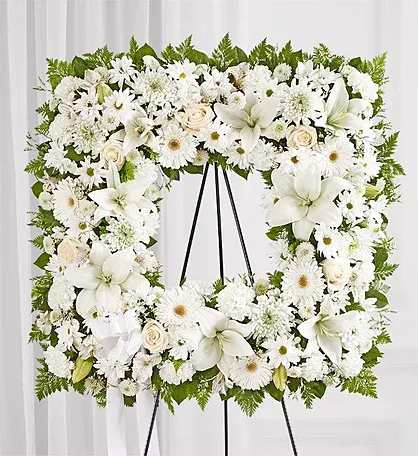 White floral wreath on a black easel