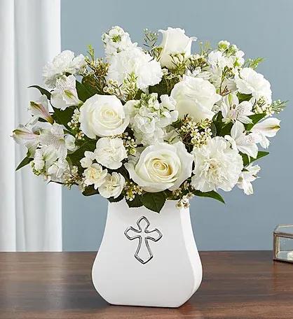 White floral arrangement in a vase with a cross emblem