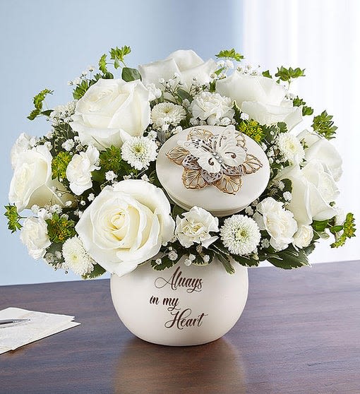 White rose arrangement in a round vase with a butterfly ornament