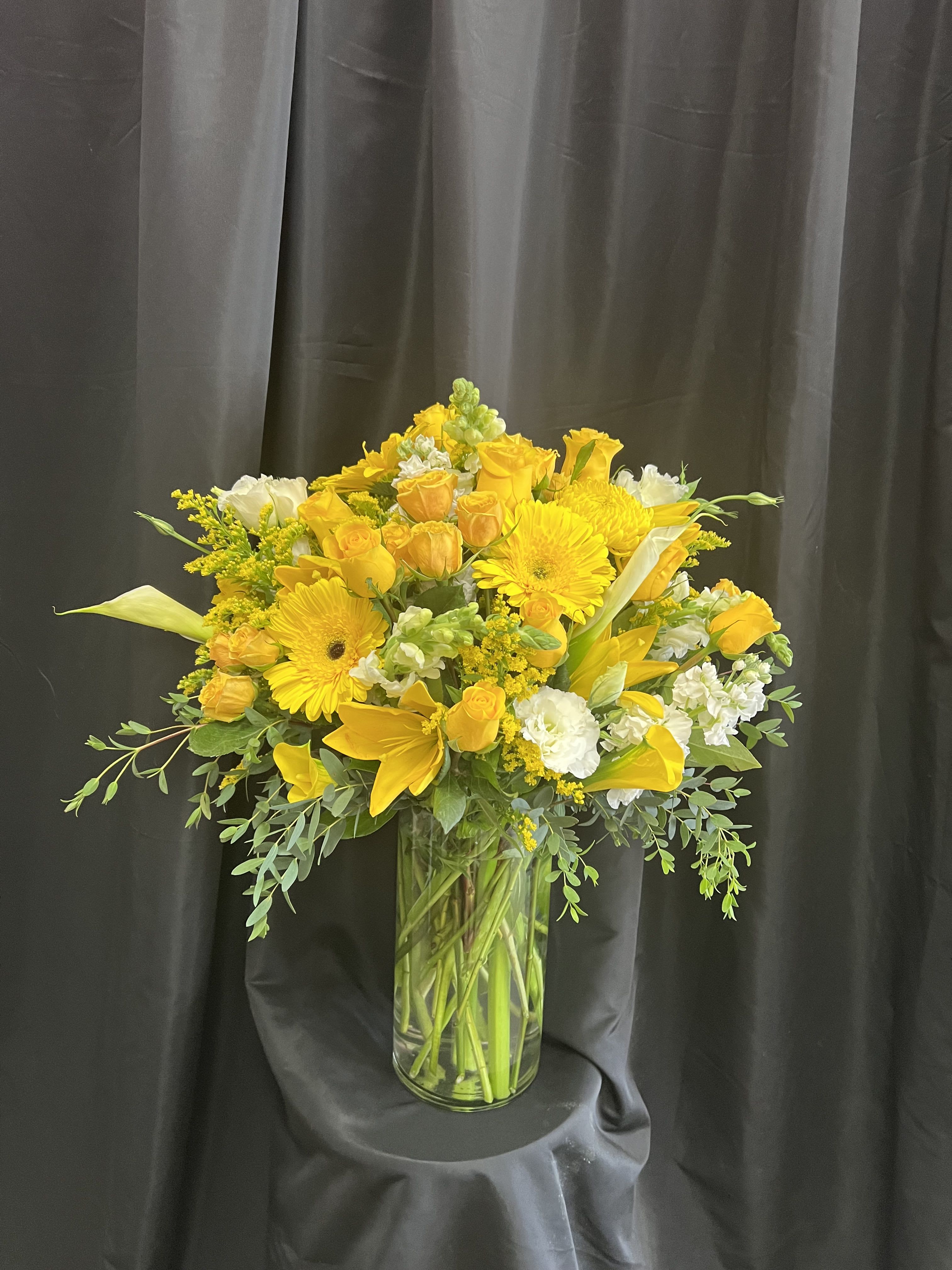 Yellow floral arrangement in a clear glass vase