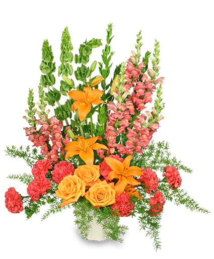 Orange lilies and roses with pink snapdragons in a white container