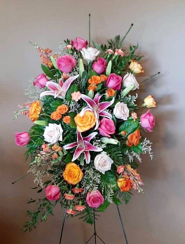 Standing floral spray with pink, white, and orange roses and lilies
