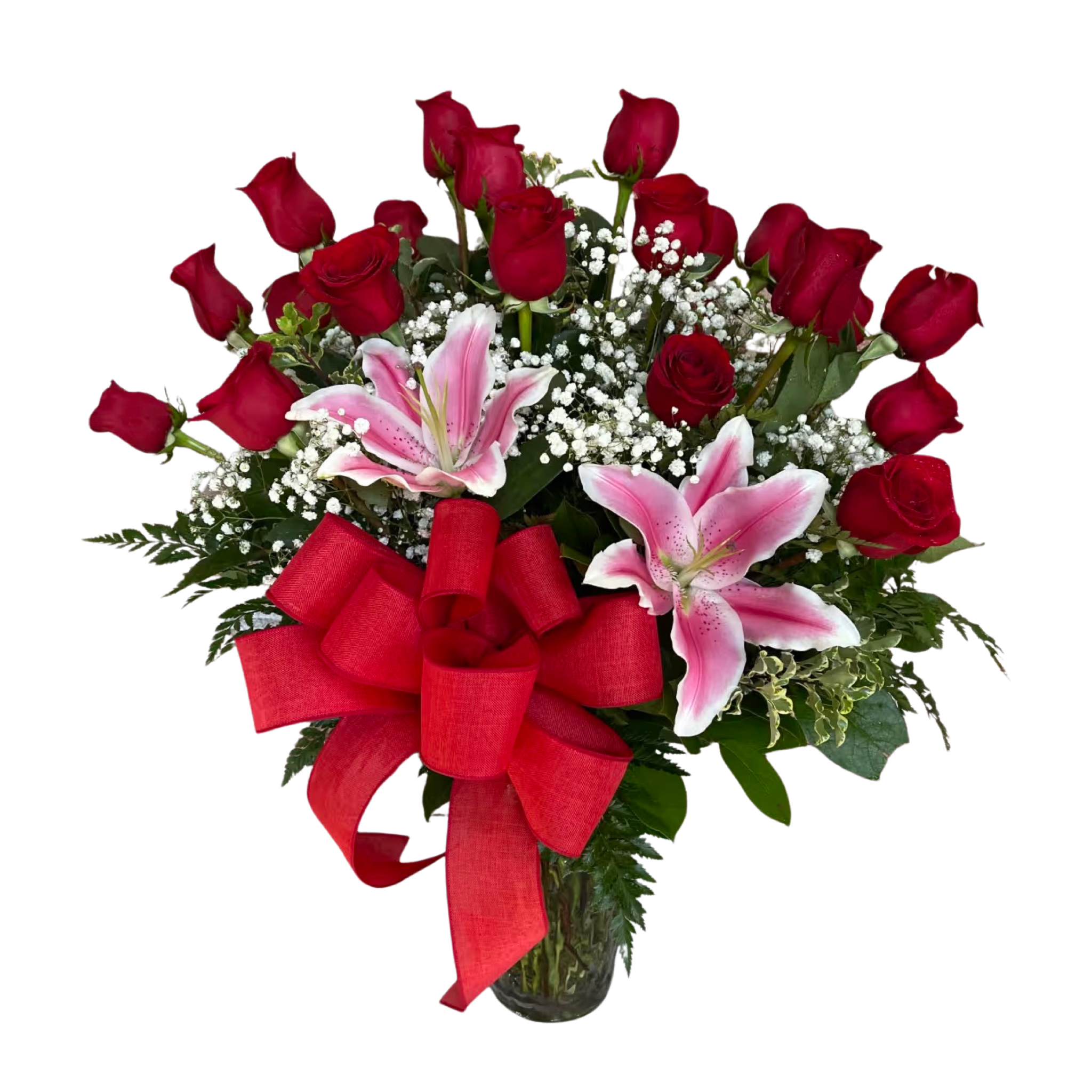 Arrangement of red roses, pink lilies, and white filler flowers in a clear glass vase with a large red bow