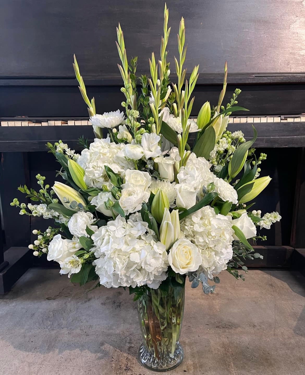 Pure Elegance  - This large arrangement includes mixtures of white florals ideal for all occasions. A touch of all white florals front faced arranged in vase gives a feeling of pure elegance. Florals shown in photo will be similar as possible , some florals may be replaced due to availability and will have overall similar  theme. 