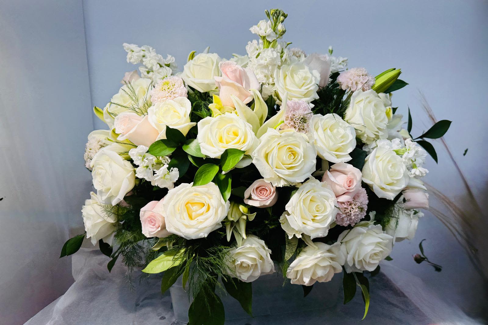 Large bouquet of white and blush roses with white filler flowers