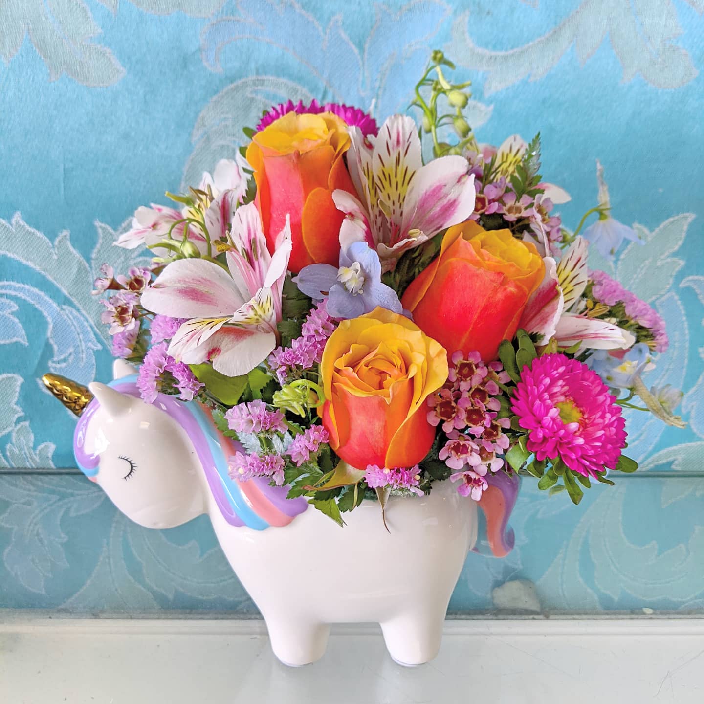 Bouquet of multicolored flowers in a unicorn-shaped vase