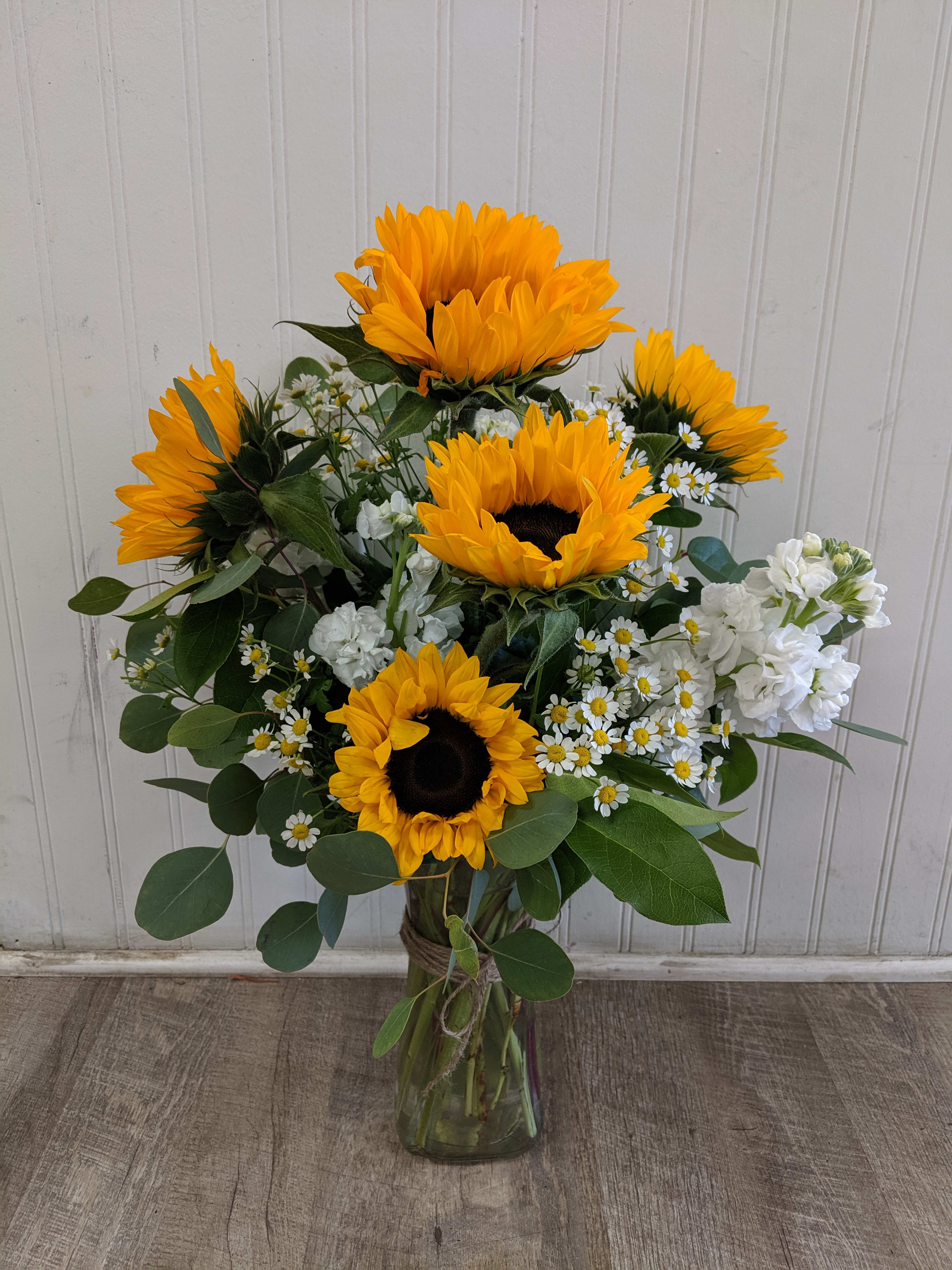 Sunflower bouquet in a glass vase with white filler flowers