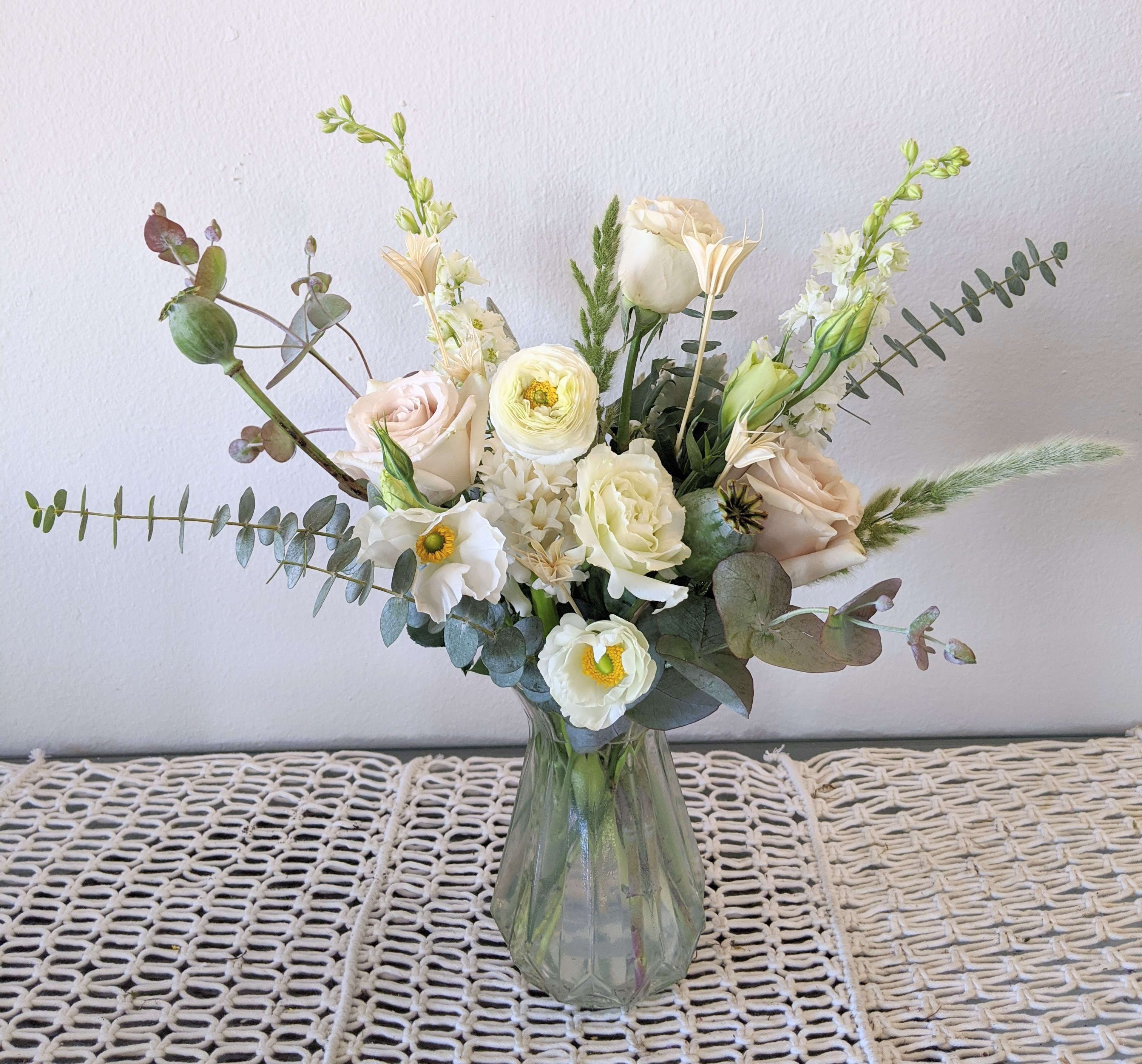 White and blush bouquet in a clear glass vase
