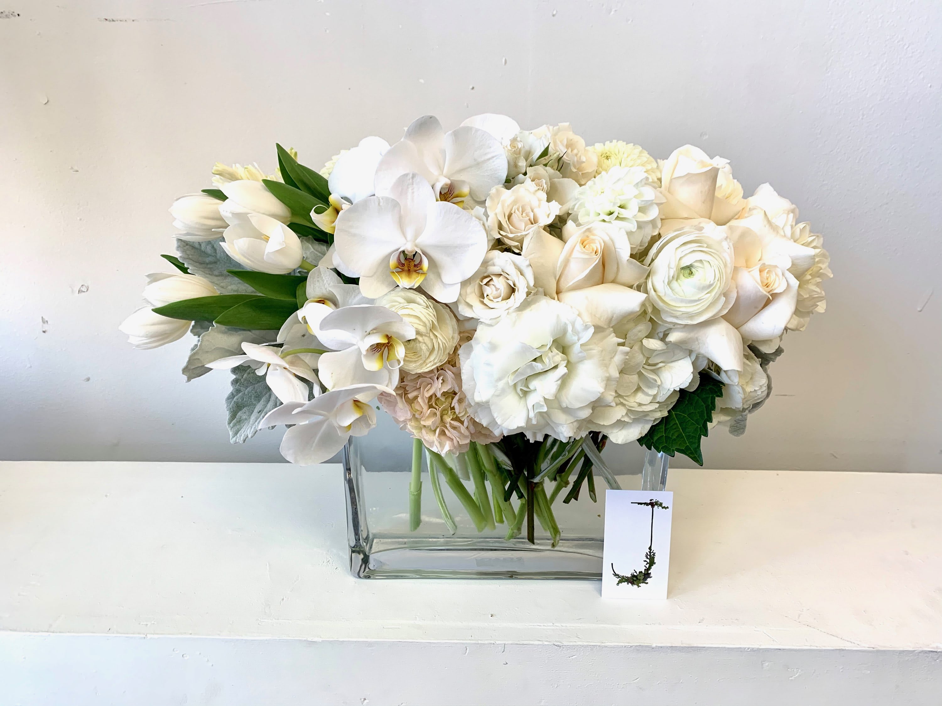 White floral arrangement in a clear rectangular vase