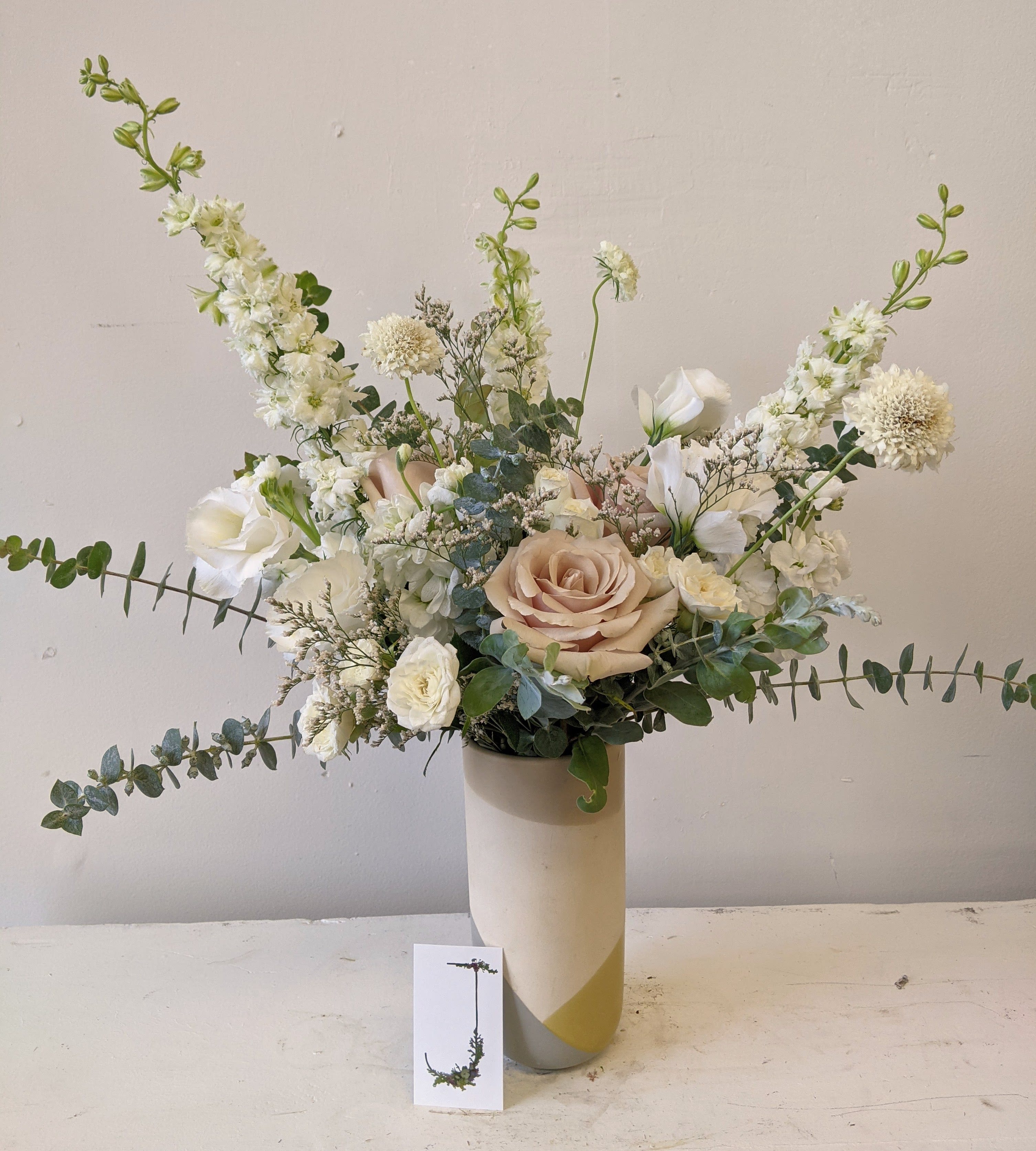 White and blush floral arrangement in a tall vase