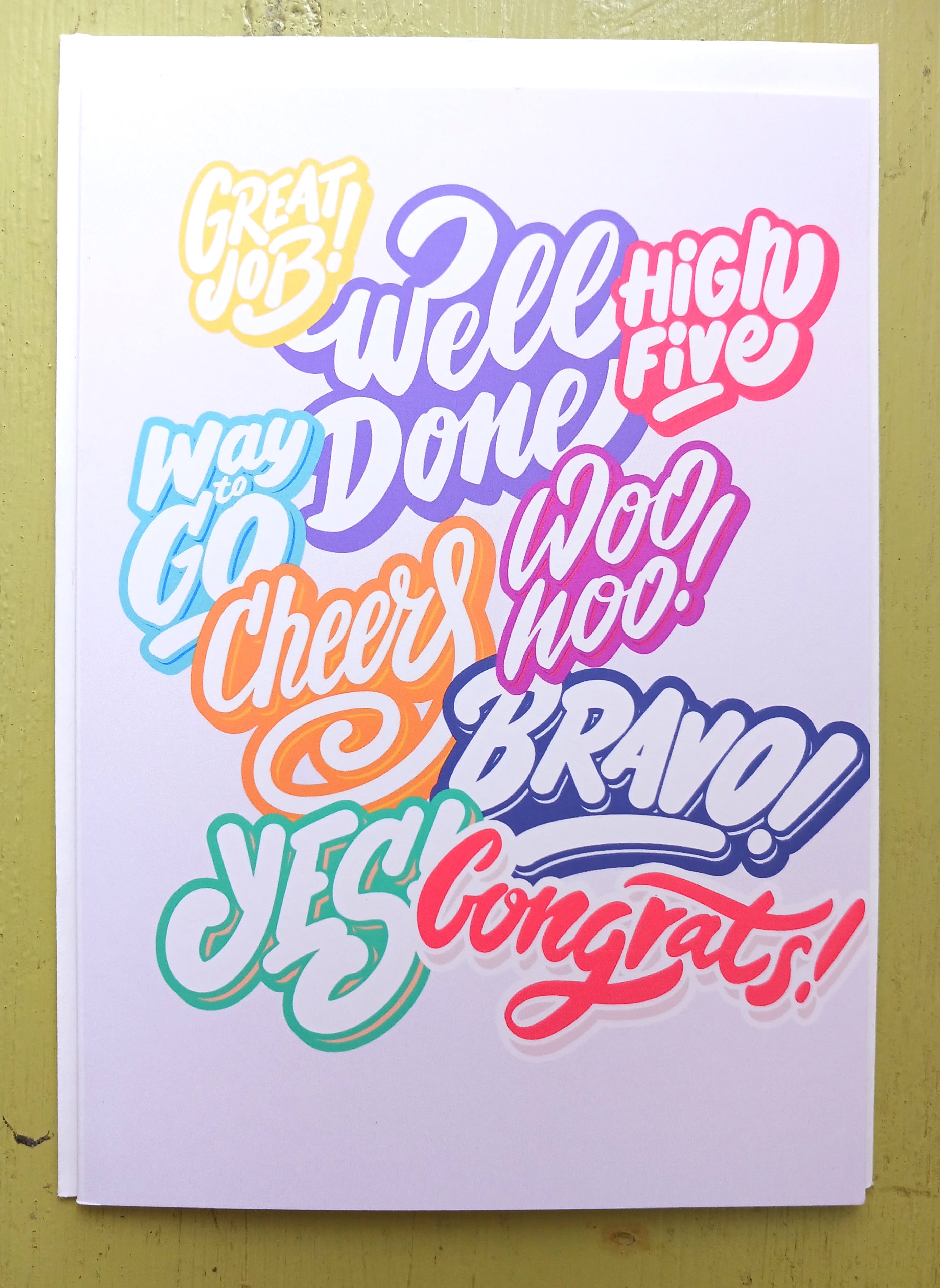 Colorful congratulations greeting card with bold hand-lettered phrases on a white background