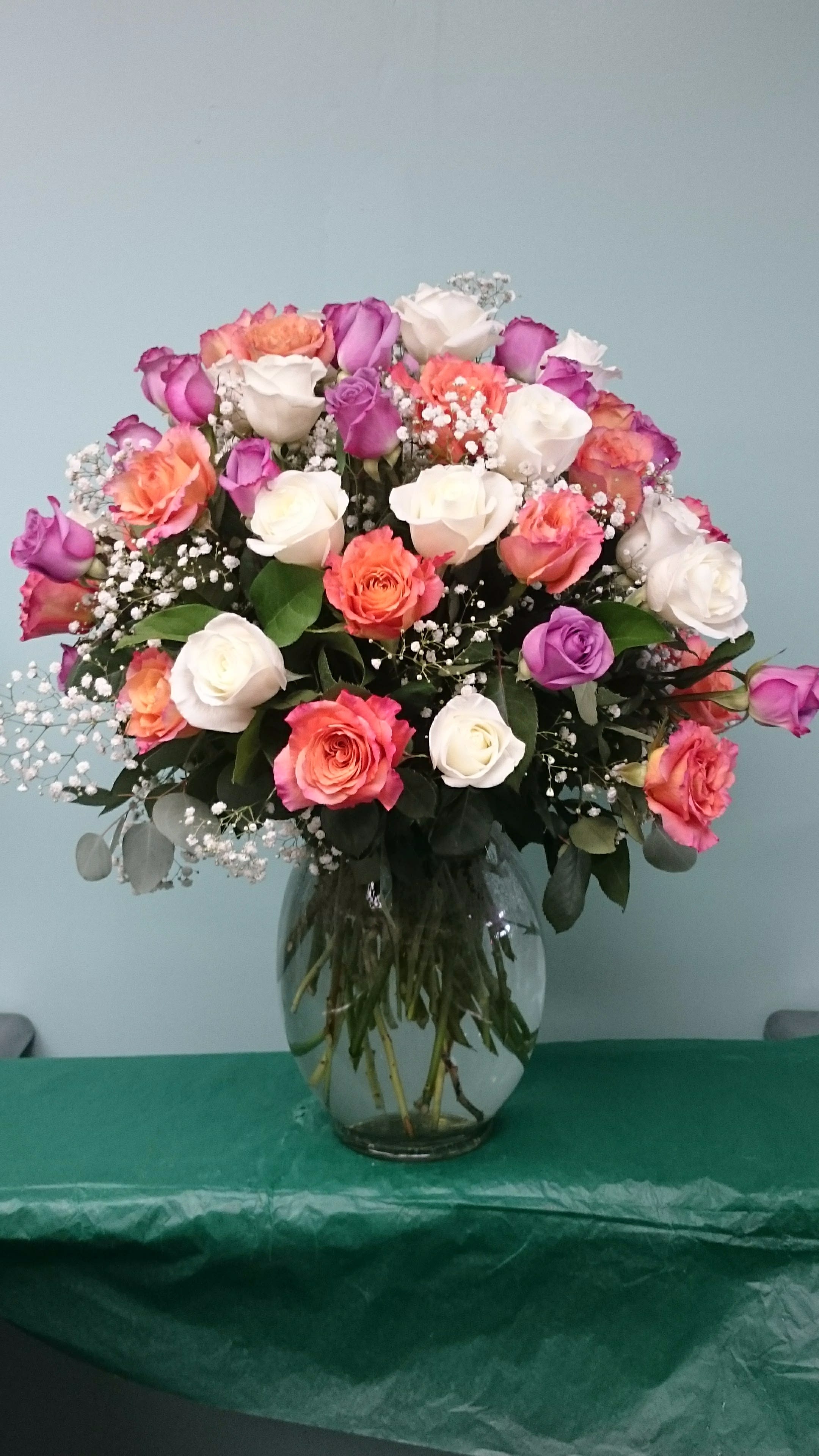 Everythings Coming Up Roses - Beautiful Arrangement filled with sixty-two multi-colored Roses or similar flowers filled with Gypsophila and lush foliage.  