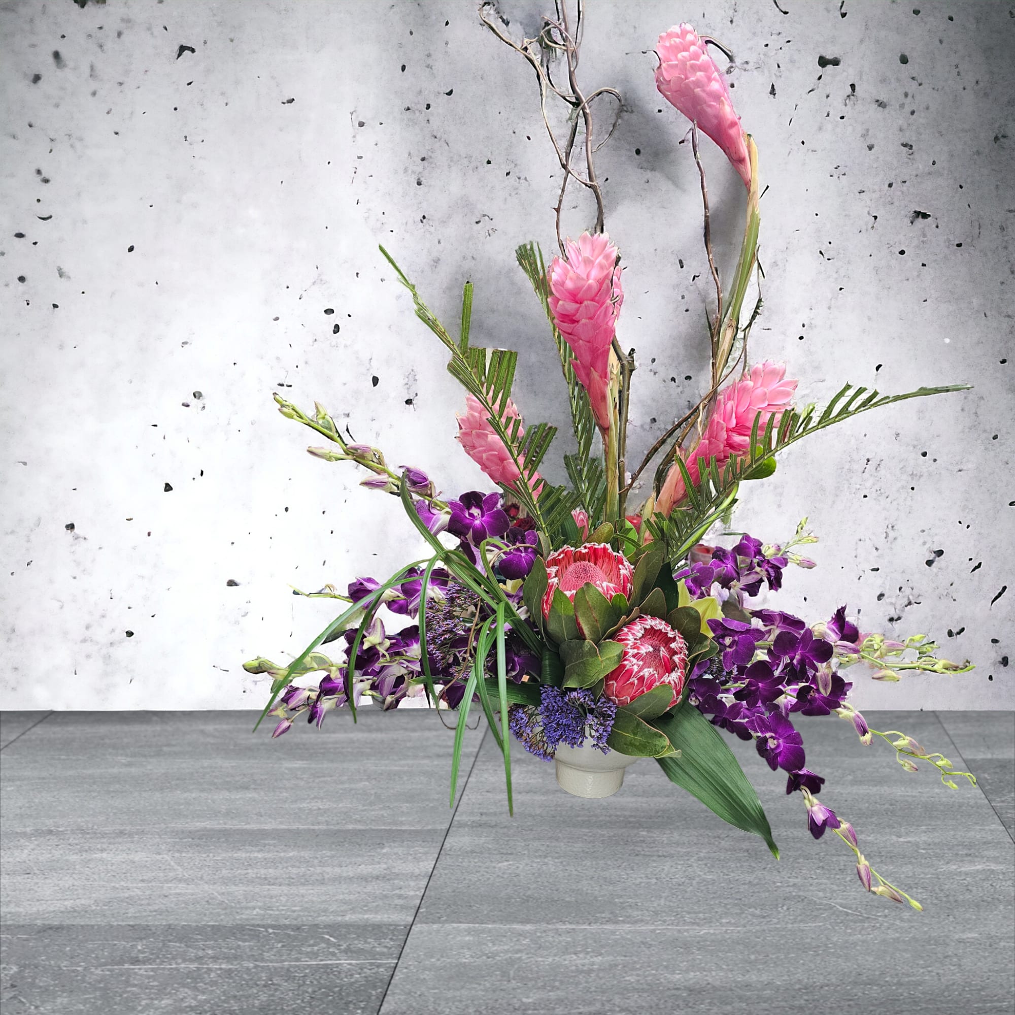 Tropically Pink - Pink Ginger and Protea make a sweet tropical expression for an Event, Grand Opening or Just Because. Vessel may vary depending on availability.  Please allow time for procurement of tropical flowers. PREMIUM SIZE IS PICTURED ***PLEASE NOTE: ALL TROPICAL ARRANGEMENT ORDERS NEED TO BE PLACED AT LEAST 3 DAYS PRIOR TO DELIVERY AS AVAILABILITY IS NOT GUARANTEED ***