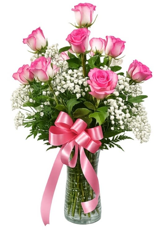 Dozen Long Stemmed Pink Roses with Baby's Breath - Soft pink roses clustered with lacy white baby's breath create an instantly romantic bouquet-perfect as a birthday, anniversary, or Mother's Day flower arrangement. The dozen long-stemmed roses are arranged upright in a rounded, layered silhouette so several blooms rise above the main cluster, giving a fresh, full look that reads both feminine and celebratory for occasions from Valentine's Day and weddings to "just because" moments.  Set in a tall clear glass vase and finished with a wide pink satin ribbon, this arrangement measures approximately 17 1/2" W x 20 1/2" H and puts the focus on color and texture: blush pink petals, airy white gypsophila, and fresh green foliage. It's the kind of gift that makes a new mom feel cherished, comforts someone who's under the weather, or says "I'm thinking of you" with timeless elegance-also lovely for holiday gatherings like Christmas or Thanksgiving without feeling seasonal.