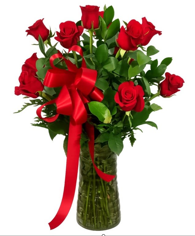 Classic Long Stemmed Red Roses - A dozen long-stemmed red roses gathered in a tall clear glass vase tied with a generous red satin ribbon - the first impression is pure, traditional romance. This flower arrangement and anniversary roses bouquet is designed to make the person you're thinking of feel deeply celebrated, whether it's for Valentine's Day, a birthday, an anniversary, or simply a "just because" moment that says I love you.  The stems stand upright with full, velvety red blooms and glossy green foliage that creates a striking contrast against the petals and the clear vase. Clean, classic lines and the polished red satin bow give the arrangement an elegant, formal presence that also works beautifully for graduations, Mother's Day, or as a get well or thank you gift. Sized to show, the tall vase gives the roses room to breathe and display their natural silhouette.  Perfect for holiday tables at Christmas or Thanksgiving and versatile enough for spring and summer celebrations, this arrangement is also a thoughtful choice for saying I'm sorry, welcoming a new baby, or honoring Women's Day or Admin Professionals' Week. For best enjoyment, trim stems and refresh the water every few days to keep the blooms bright and long-lasting.