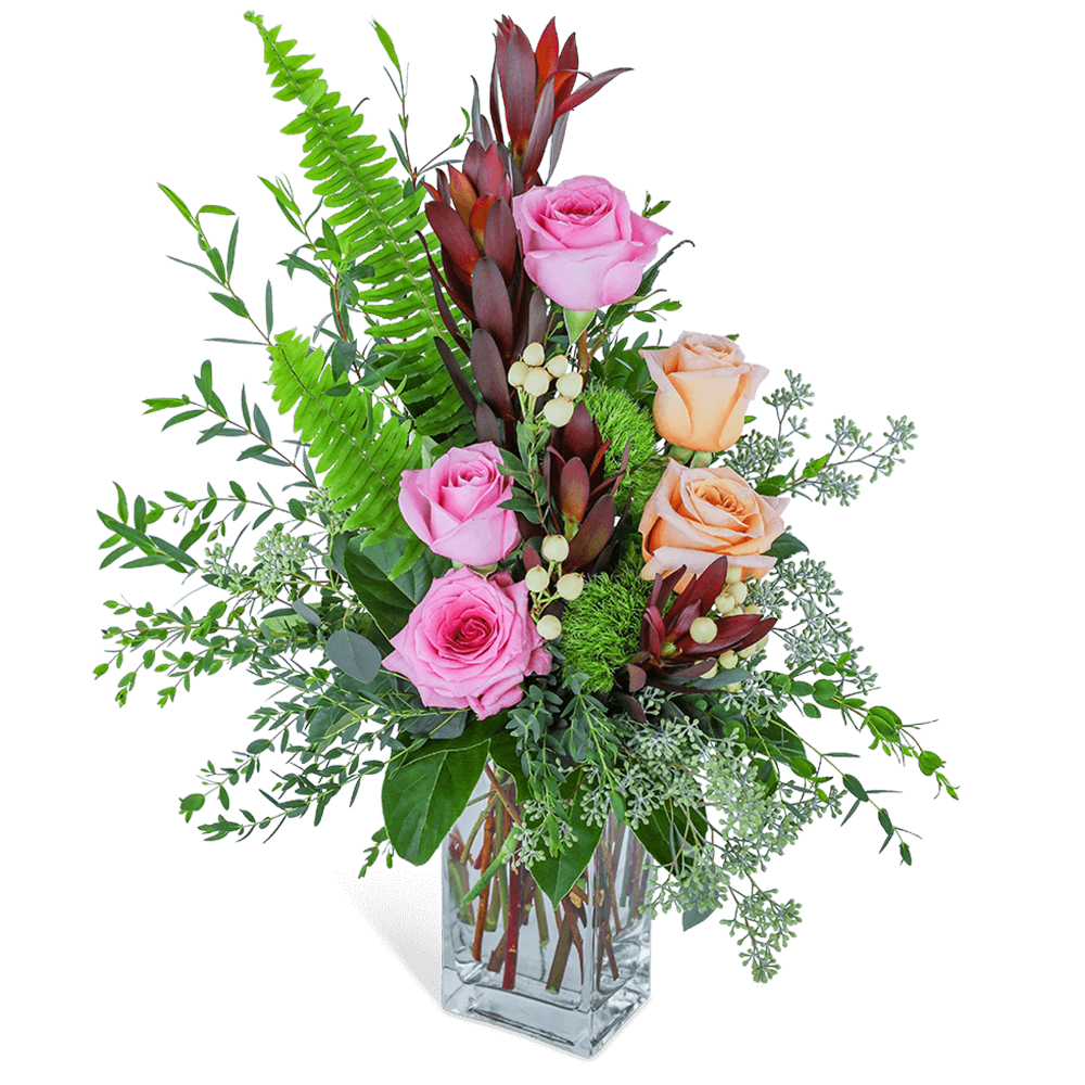 Pink and peach roses in a clear glass vase with mixed greenery