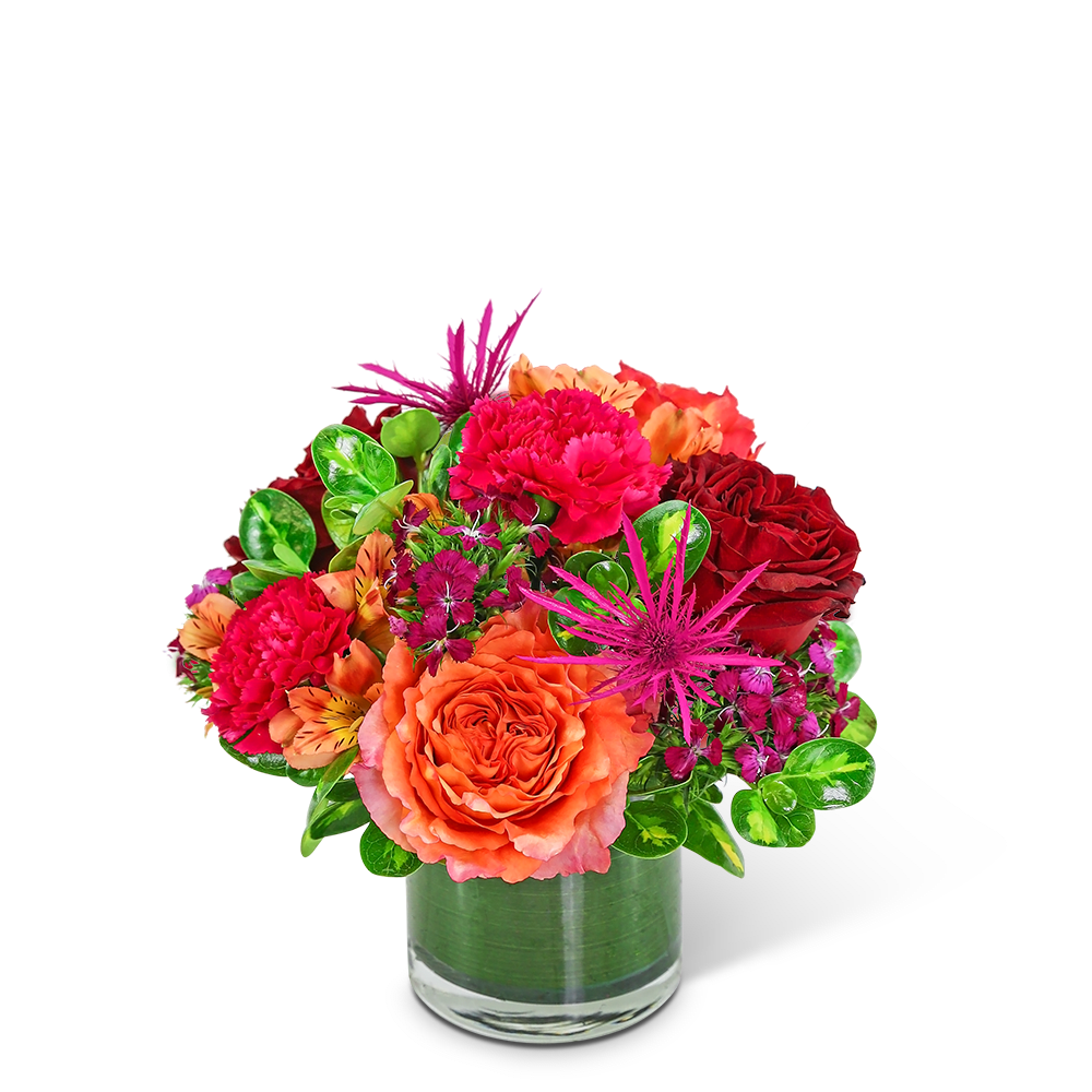 Bright mixed bouquet in a clear glass vase with orange and red blooms