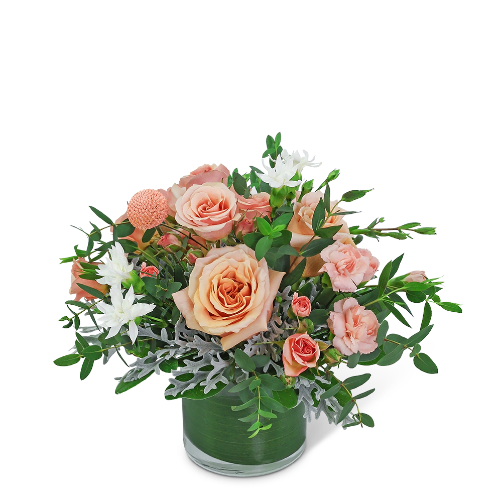 Peach roses and white flowers in a green glass vase