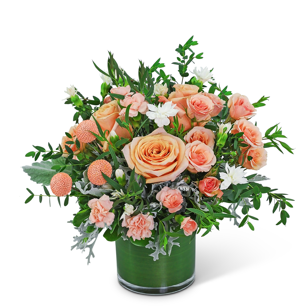 Peach roses and white flowers in a green glass vase