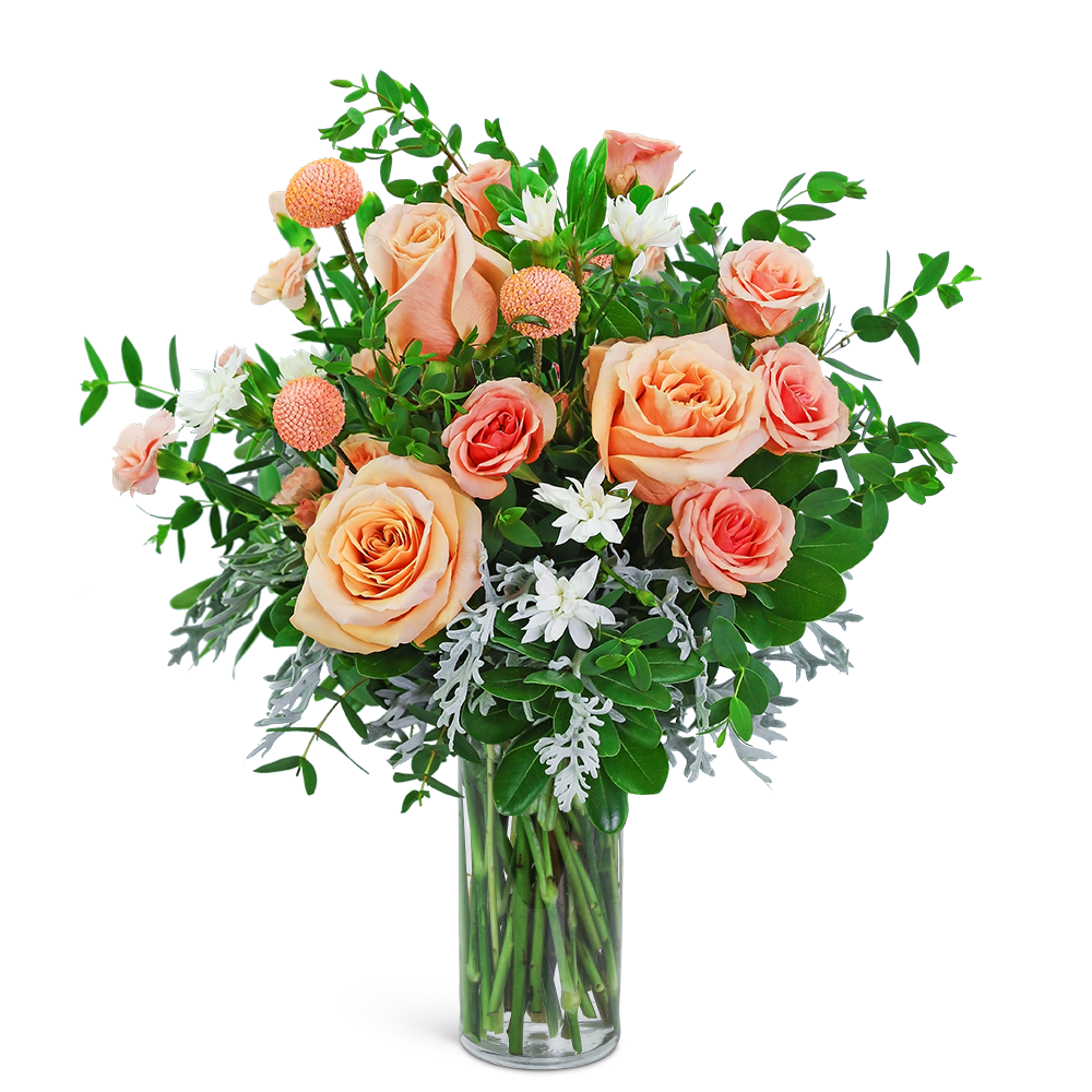 Peach and coral roses in a clear glass vase with white accent flowers