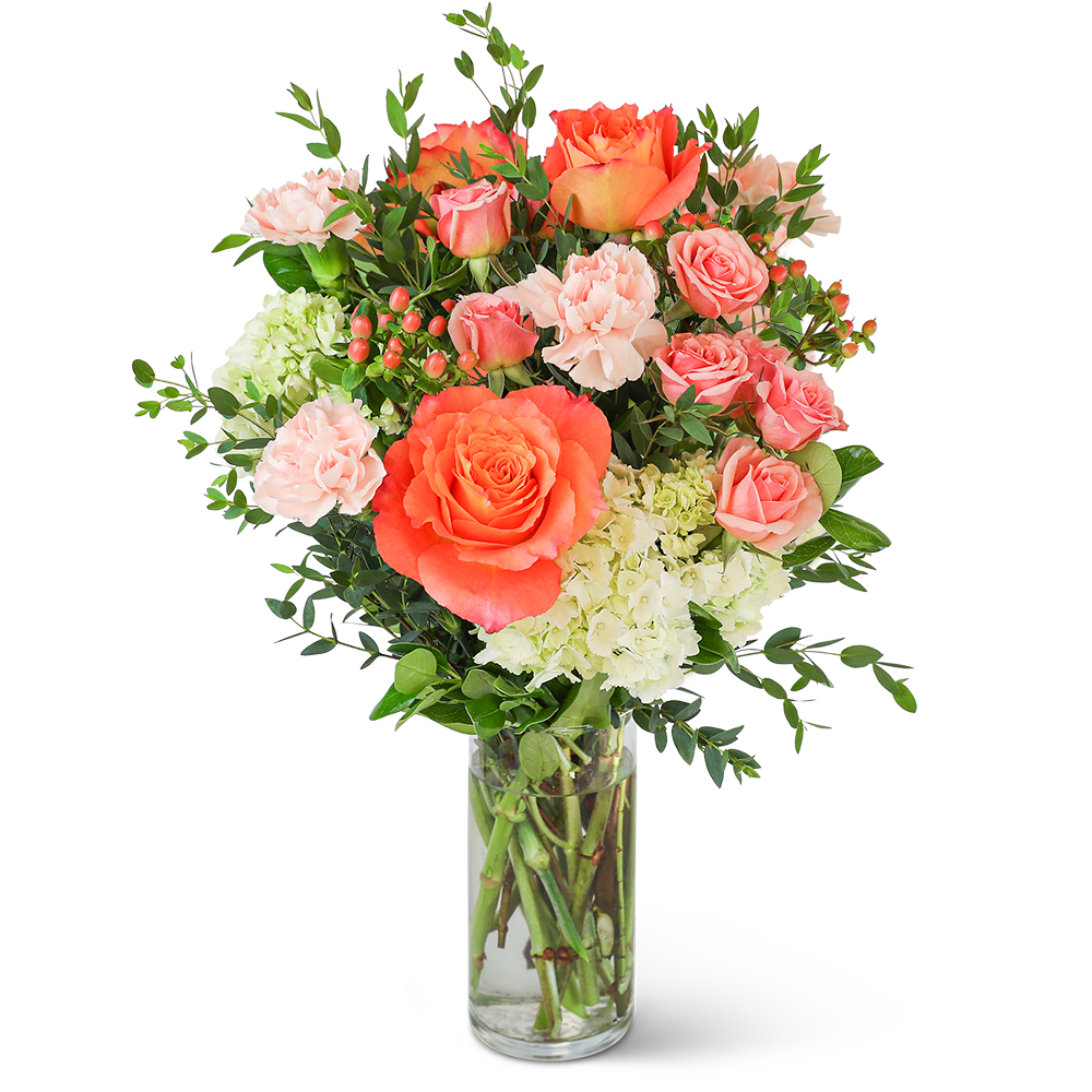 Coral and pink roses with carnations in a clear glass vase