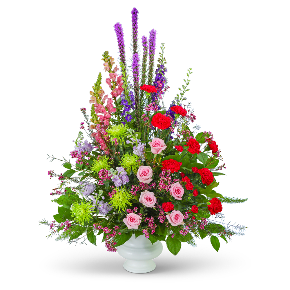 Tall mixed bouquet of pink, red, and purple flowers in a white vase