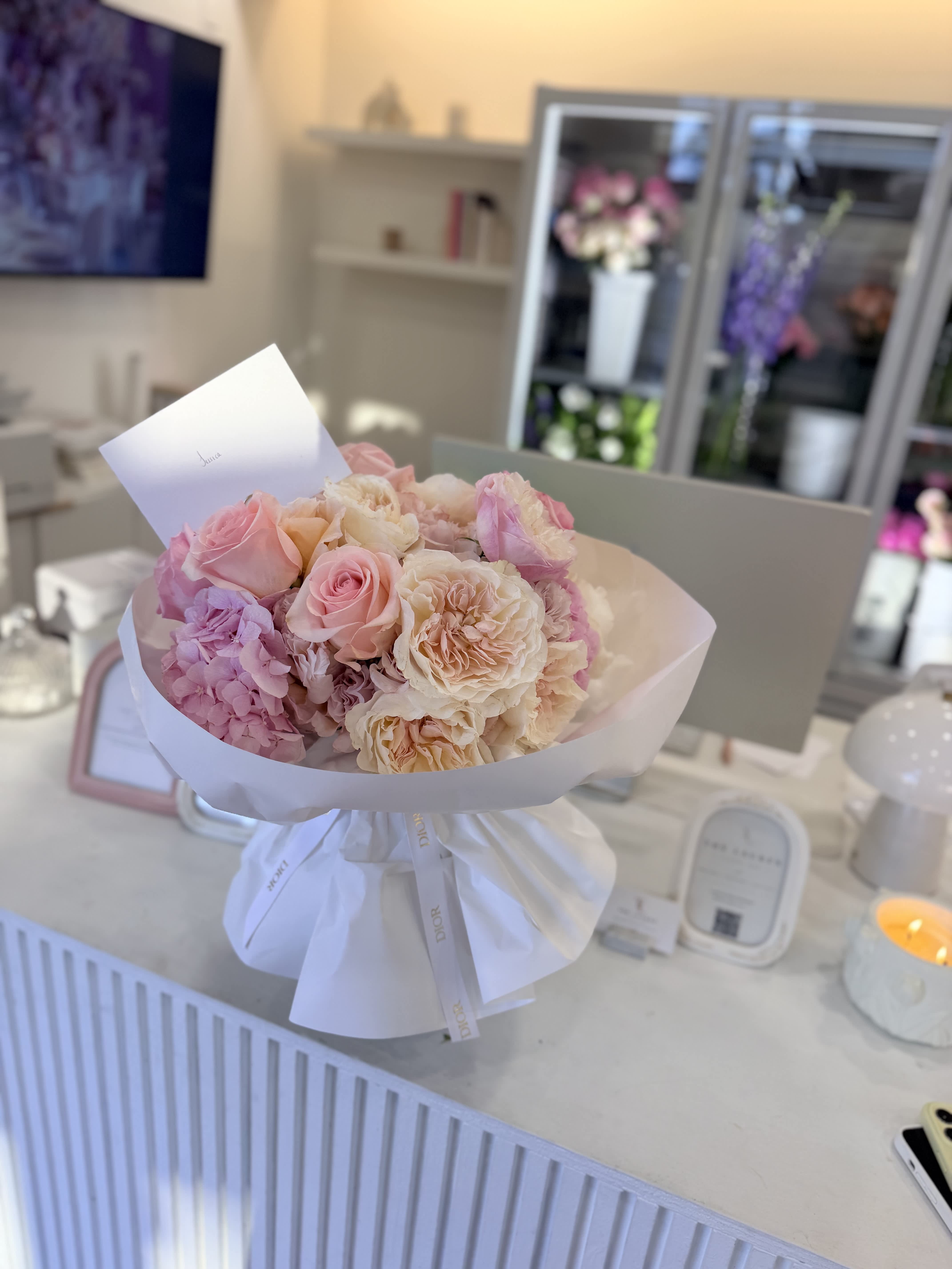 Bouquet of pink and cream roses wrapped in white paper