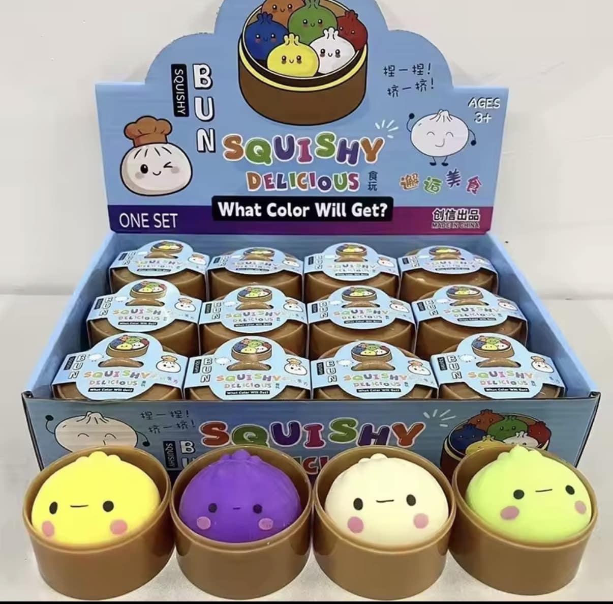 Display box of colorful squishy toy buns in round containers