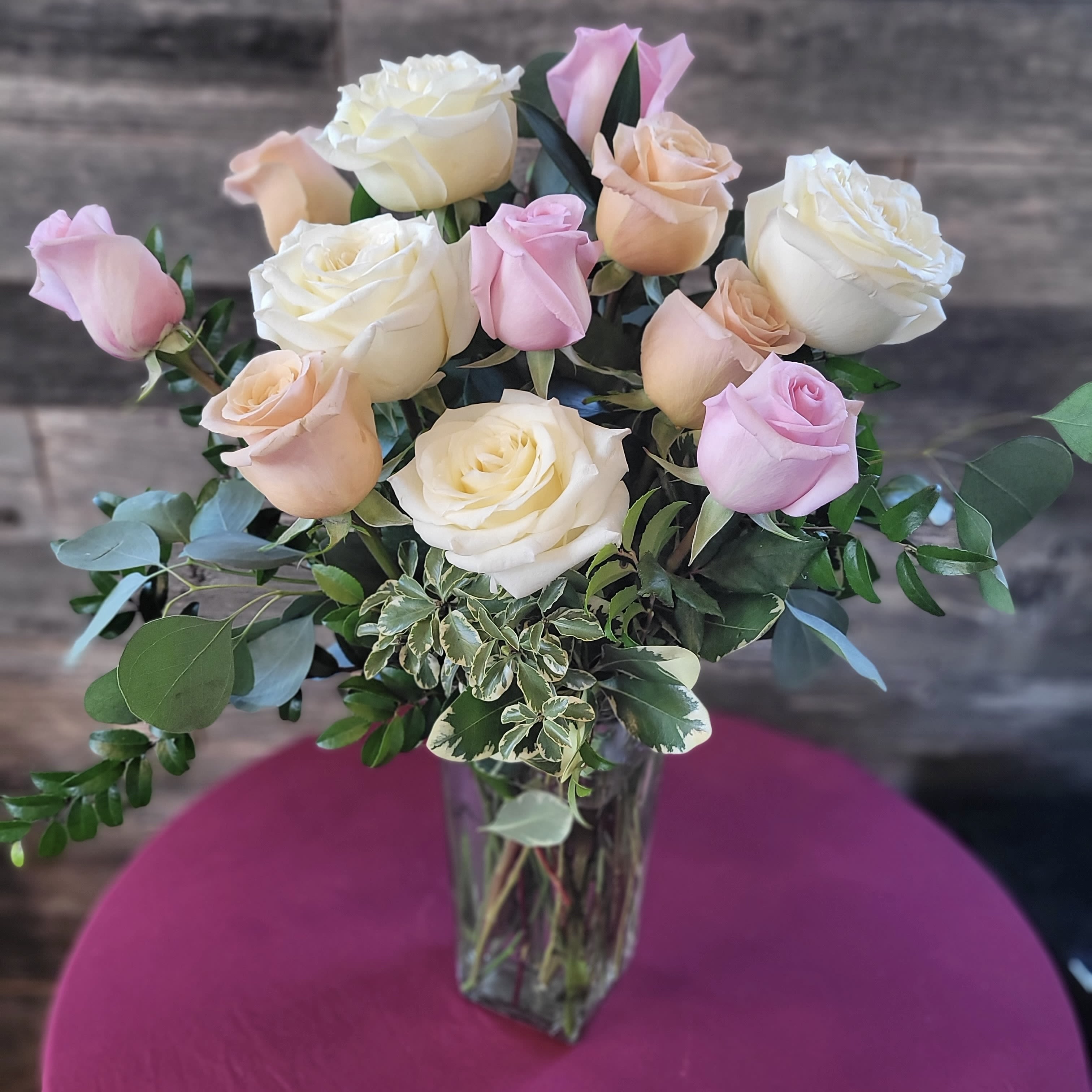 Mixed color designers choice dozen roses  - Beautiful mixed  color roses with  trendy greenery in a clear glass vase .    Designers Choice of mix,  Depending on what colors are in this week.  Can be a 2, 3, or 4 way mix 