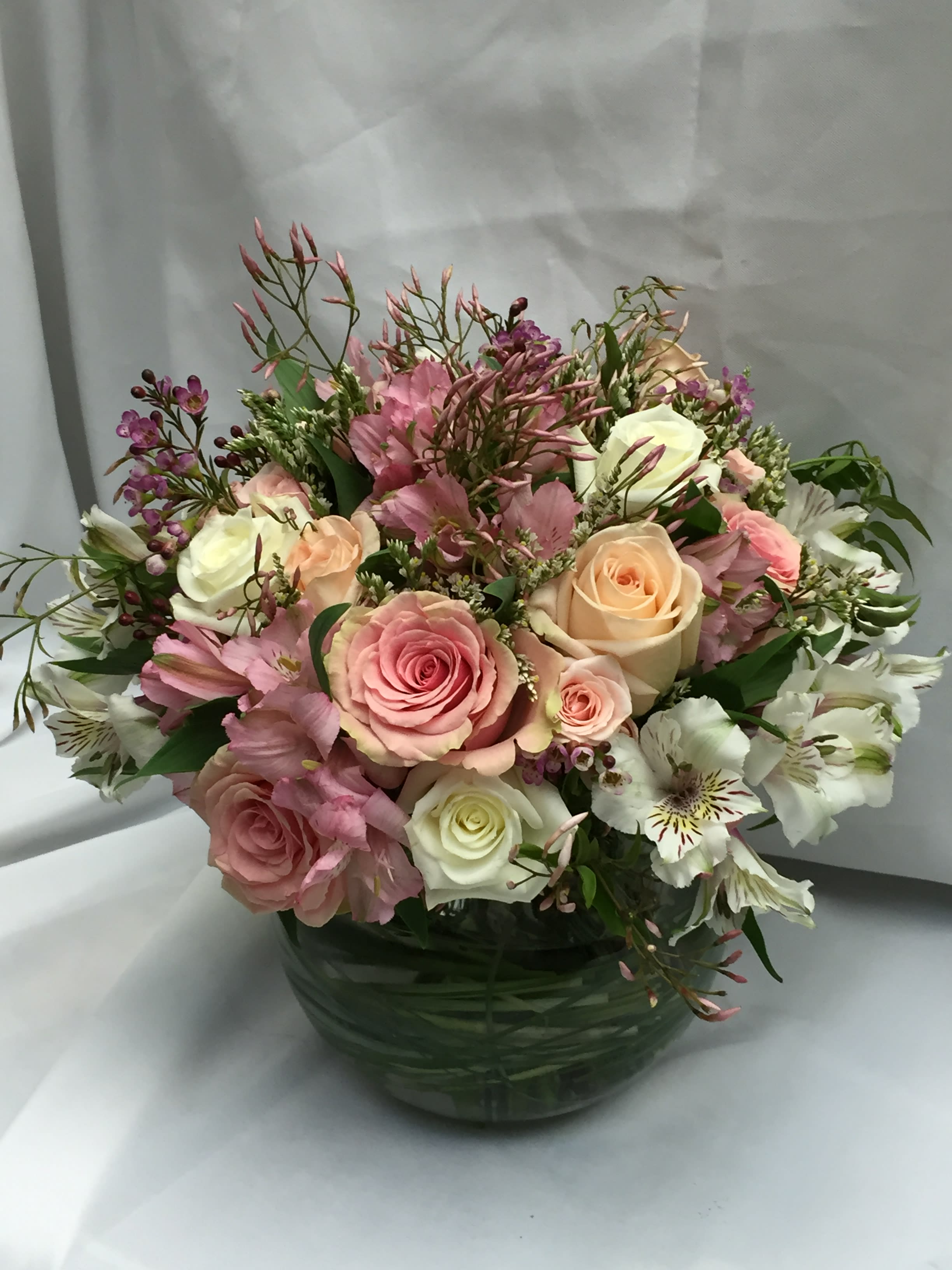 Pastel Pink Bowl of Beauty - Glass bowl filled with assorted pink blossoms with a touch of white for softness. Selection varies daily/seasonally but will generally include roses, spray roses, alstromeria and more. 