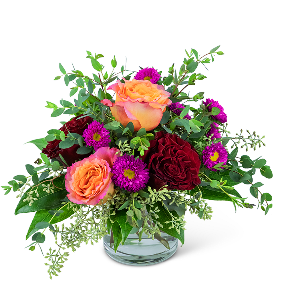 Peach and burgundy roses with purple daisies in a glass vase