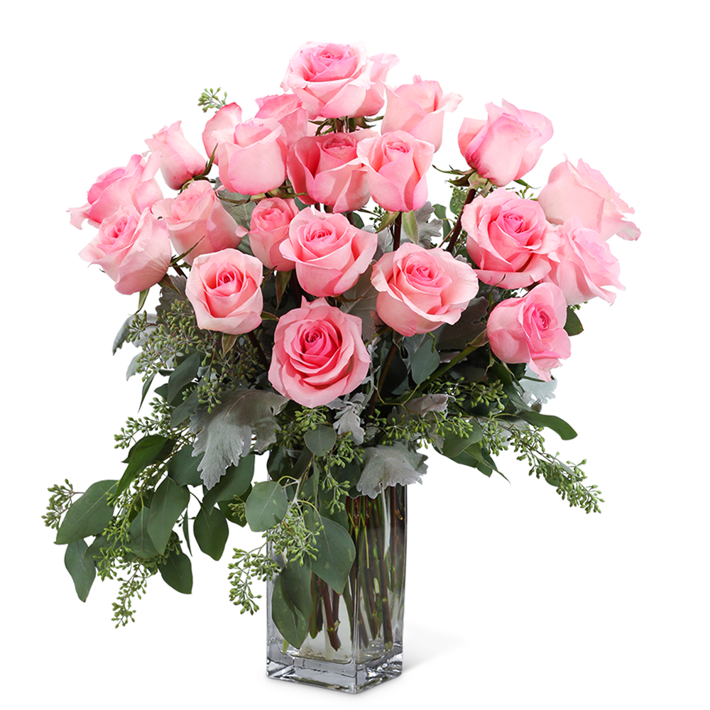 Pink roses arranged in a clear glass vase with greenery