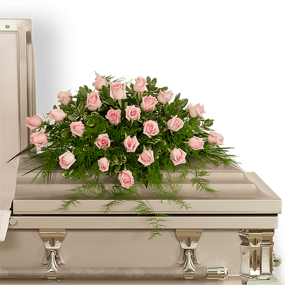 Pink rose casket spray with greenery on a silver casket