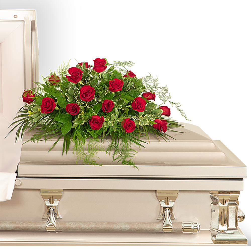 Red rose arrangement on a white casket