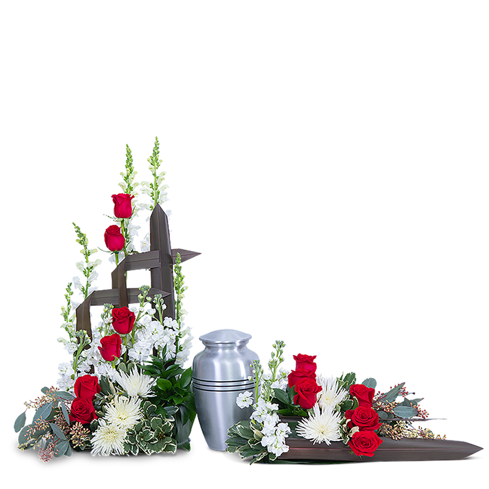 Red roses and white flowers arranged around a silver urn and wooden cross