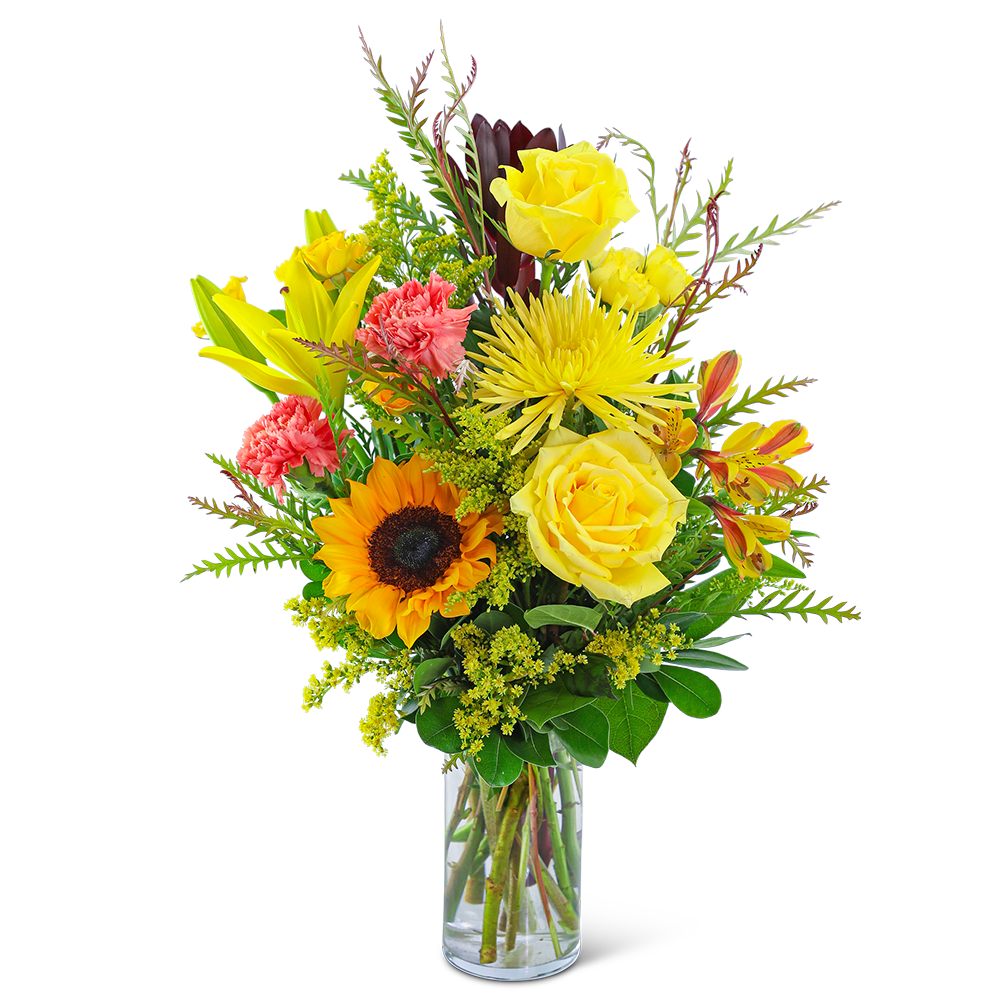 Mixed bouquet of yellow roses, sunflower, lilies, and carnations in a glass vase