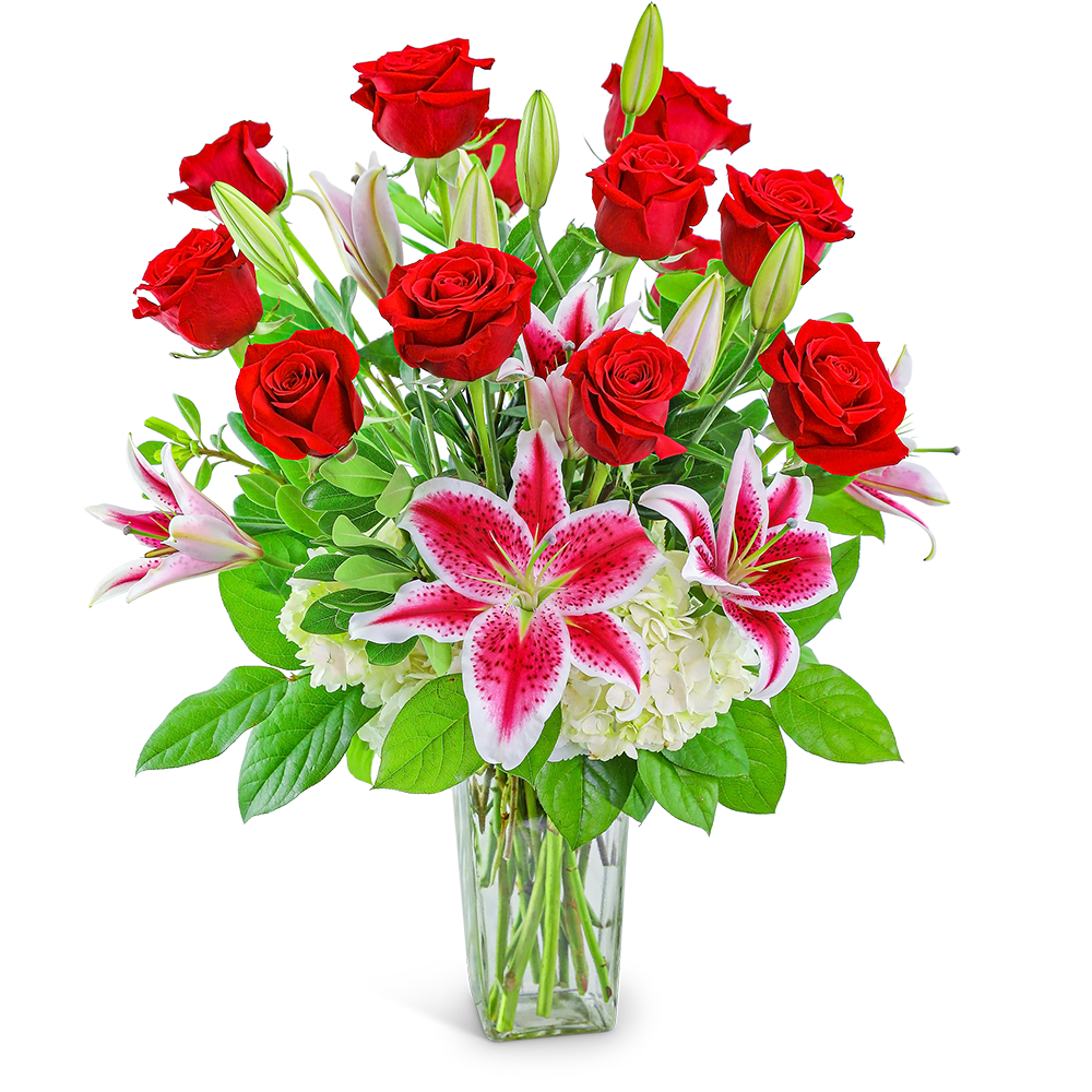 Bouquet of red roses and pink lilies in a clear glass vase