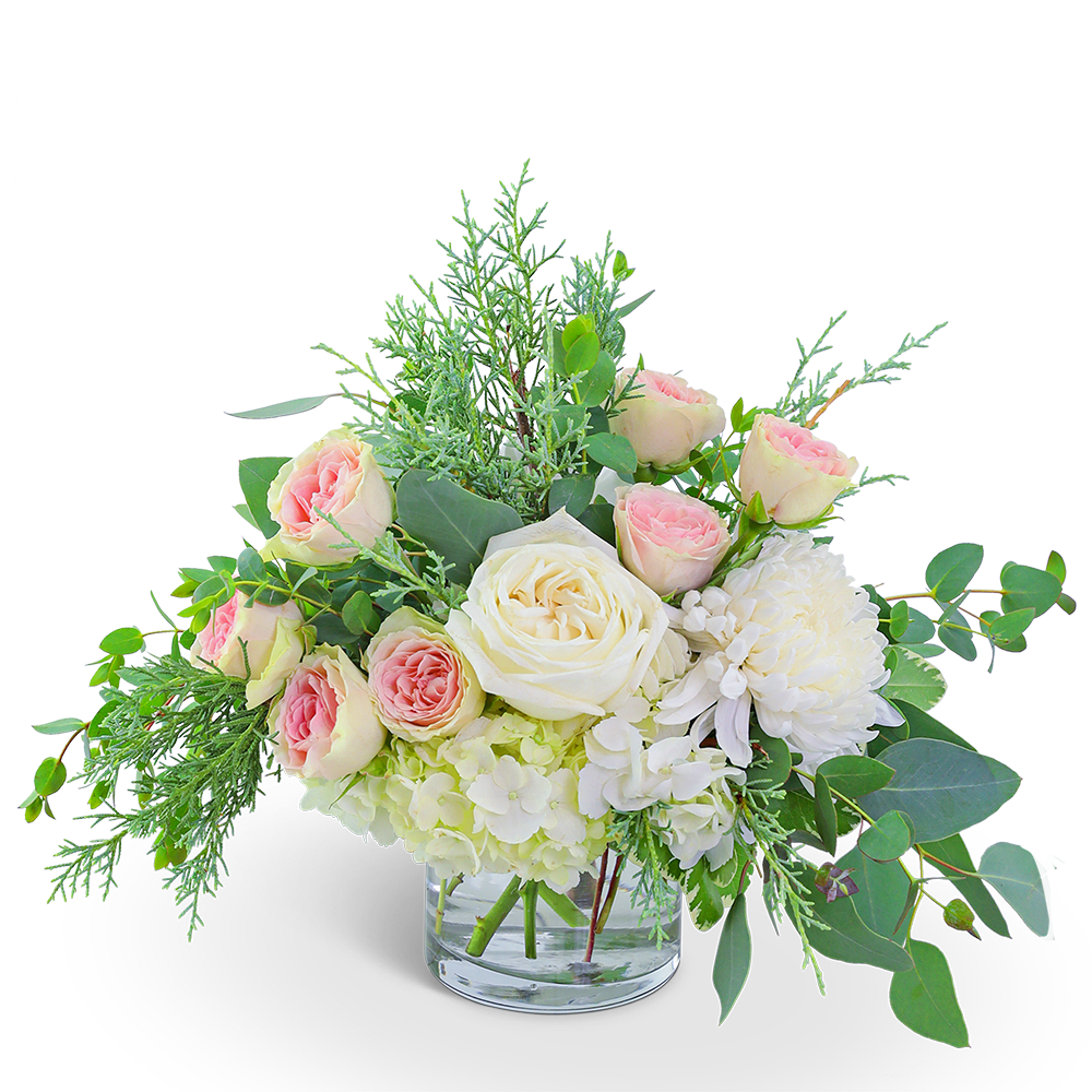 Bouquet of blush and white roses in a clear glass vase