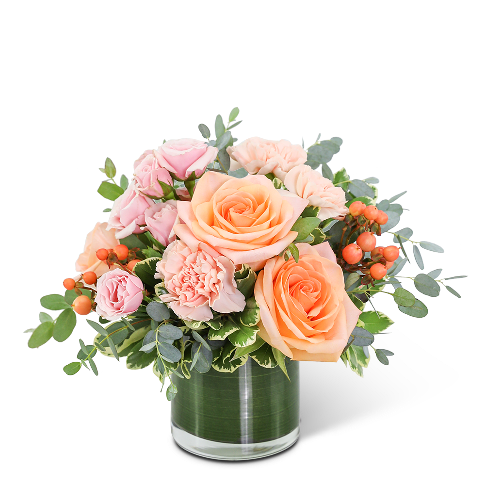 Peach and pink roses with carnations in a glass vase