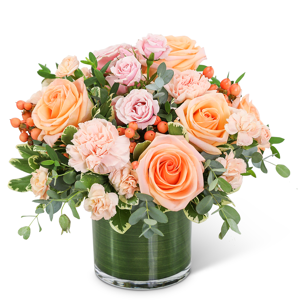 Peach and pink roses with carnations in a glass vase