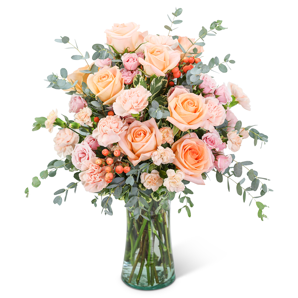Peach and pink roses with carnations in a clear glass vase