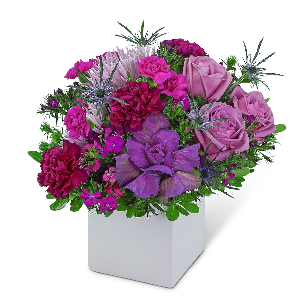 Purple and pink floral arrangement in a white square vase