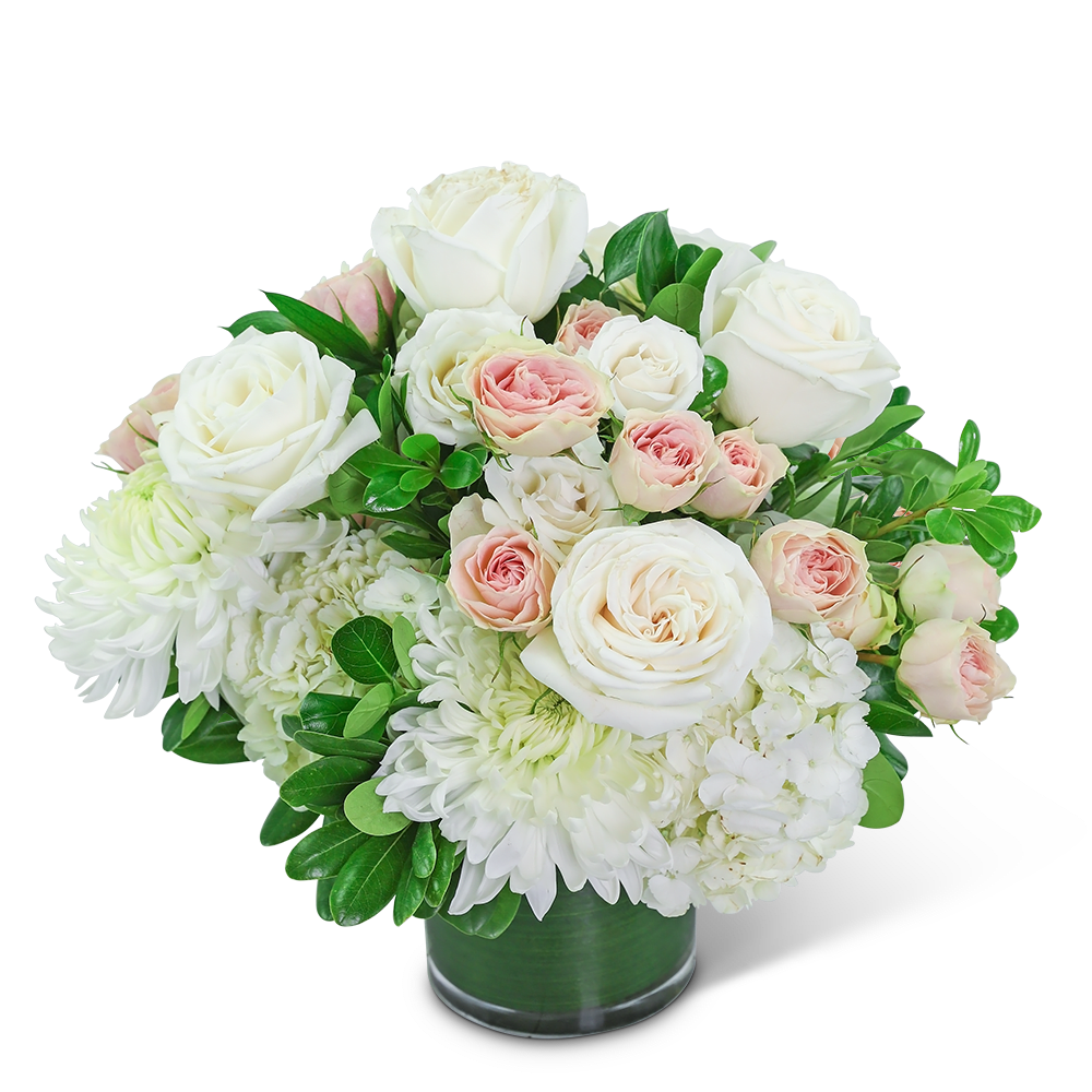 White and blush roses arranged in a glass vase